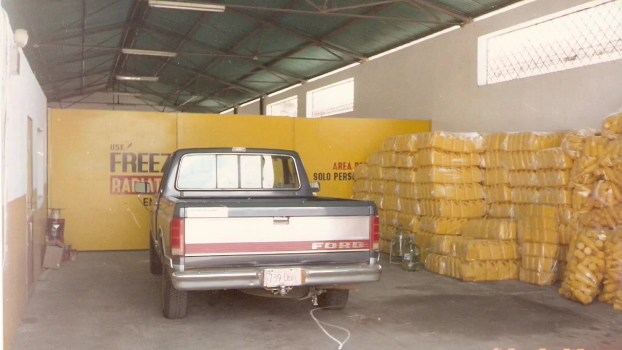 Fotografía del archivo de la empresa: una camioneta estacionada en una bodega junto a productos almacenados.